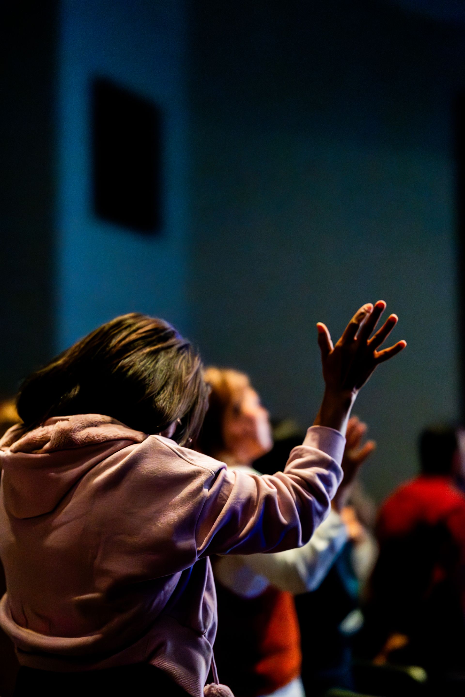 A worshipper with hand raised during a Sunday church service